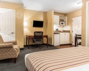 a hotel room with a bed and a desk and a chair at Suburban Studios Kennesaw-Marietta North in Kennesaw