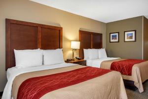 a hotel room with two beds with red sheets at Comfort Inn Sandy Springs - Perimeter in Atlanta