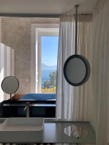 a bathroom with a mirror and a sink and a window at PrimoPianoPosillipo in Naples
