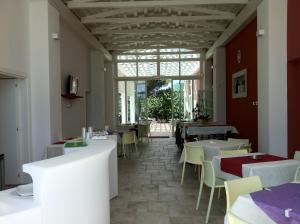 restauracja ze stołami i krzesłami oraz oknem w obiekcie Loggia Dei Lezzi w mieście Noci