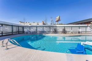 una piscina con sedie blu e recinzione di Rodeway Inn ad Augusta