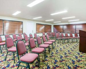 einen Konferenzraum mit rosa Stühlen und einem Podium in der Unterkunft Quality Inn Macon in Macon