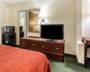 a hotel room with a bed and a flat screen tv at Quality Inn & Suites Stockbridge Atlanta South I-75 in Stockbridge