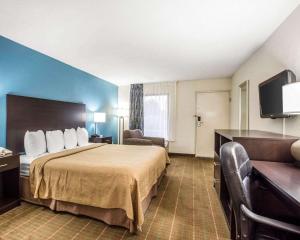 a hotel room with a bed and a flat screen tv at Quality Inn in Macon +20 photos