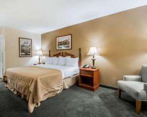 a hotel room with a bed and a chair at Quality Inn in Bainbridge +35 photos