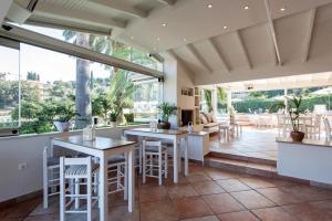 a dining room with tables and chairs and large windows at Anita in Perama