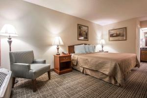 Habitación de hotel con cama y silla en Quality Inn Waynesboro, en Waynesboro