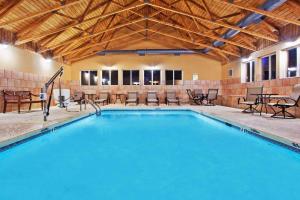 una gran piscina con sillas y mesas en un edificio en Comfort Inn Blairsville, en Blairsville