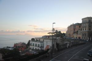 a city street with buildings and the ocean at PrimoPianoPosillipo in Naples