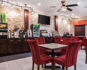a bar with red chairs and a table in a restaurant at Quality Inn & Suites Des Moines Airport in Des Moines
