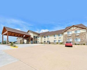 a building with a car parked in a parking lot at Comfort Inn & Suites Riverview near Davenport and I-80 in Le Claire