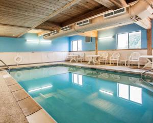 a swimming pool with tables and chairs in a building at Comfort Inn Marshalltown South in Marshalltown