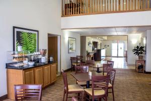 a restaurant with a table and chairs and a bar at Sleep Inn & Suites in Charles City