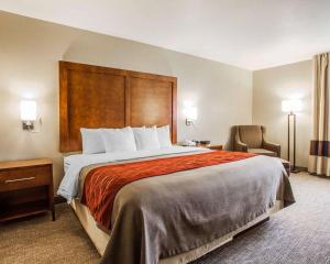 a hotel room with a large bed and a chair at Comfort Inn Marshalltown South in Marshalltown