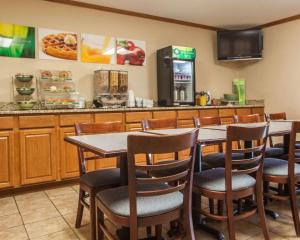 a restaurant with a table and chairs and a counter at Quality Inn & Suites Eldridge Davenport North in Eldridge
