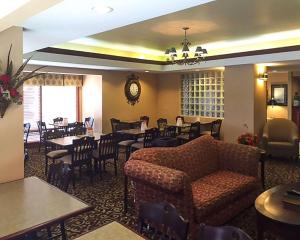 um restaurante com mesas e cadeiras e um sofá em Econo Lodge em Cordele