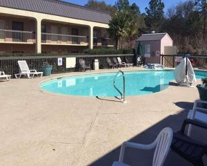 uma grande piscina com cadeiras e um edifício em Econo Lodge em Cordele