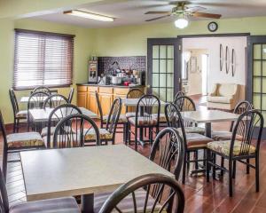 a dining room with tables and chairs and a kitchen at Econo Lodge in Ames