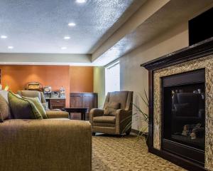 a living room with a fireplace and two chairs at MainStay Suites Coralville - Iowa City in Coralville
