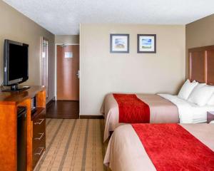 a hotel room with two beds and a flat screen tv at Comfort Inn & Suites Coralville - Iowa City near Iowa River Landing in Coralville