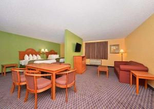 een hotelkamer met een tafel, een bed en een bank bij Quality Inn & Suites Grinnell near University in Grinnell