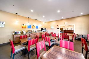 un restaurant avec des tables en bois et des chaises rouges dans l'établissement Comfort Inn & Suites Independence, à Independence