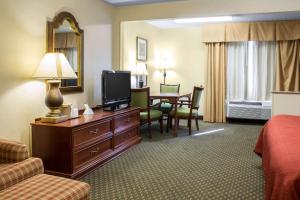 Habitación de hotel con cama, TV y mesa. en Quality Inn & Suites, en Sioux City