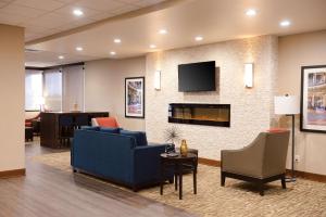 a living room with a blue couch and a fireplace at Comfort Inn & Suites Event Center in Des Moines