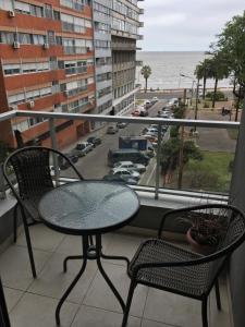 uma mesa e cadeiras numa varanda com vista para o oceano em Palm Beach em Montevidéu