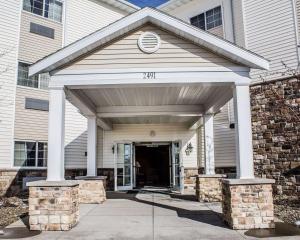 une maison blanche avec un garage et une entrée dans l'établissement MainStay Suites Coralville - Iowa City, à Coralville