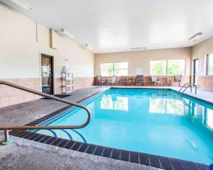 una piscina en un hotel con sillas y mesas en Quality Inn & Suites Ankeny-Des Moines, en Ankeny