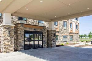 a large brick building with a large glass door at Sleep Inn & Suites Fort Dodge in Fort Dodge