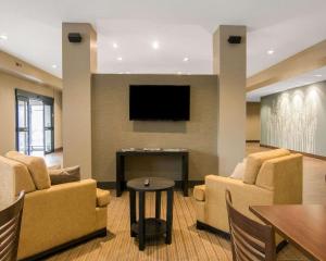 a waiting room with chairs and a flat screen tv at Sleep Inn & Suites Fort Dodge in Fort Dodge