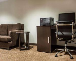 a living room with a couch and a chair and a desk at Sleep Inn in Nampa