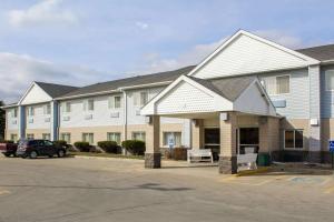 a large building with a car parked in a parking lot at Quality Inn & Suites in Sioux City