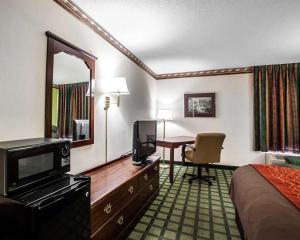 a hotel room with a bed and a desk with a television at Quality Inn in Arcola