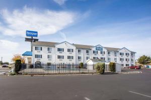 un edificio bianco con un cartello in un parcheggio di Rodeway Inn & Suites Nampa a Nampa