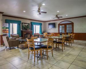 a dining room with tables and chairs and a tv at Quality Inn Peru near Starved Rock State Park in Peru