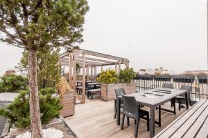 eine Terrasse mit einem Tisch und Stühlen auf einer Terrasse in der Unterkunft Apartments Vilnius 1 near center with a roof terrace and parking in Vilnius