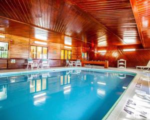 a large swimming pool with chairs and tables in a building at Quality Inn & Suites in Champaign +22 photos