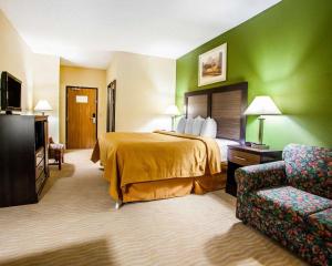 a hotel room with a bed and a chair at Quality Inn & Suites in Champaign