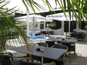 a patio with tables and chairs and a fountain at Hotel Adler in Augsburg
