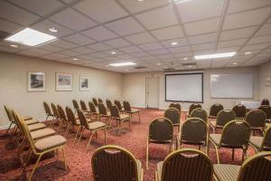 a conference room with chairs and a whiteboard and a screen at Quality Inn and Suites St Charles -West Chicago in Saint Charles