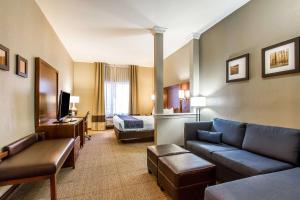 Comfort Suites في Mattoon: غرفة في الفندق مع أريكة وسرير