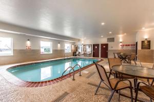 uma piscina com mesas e cadeiras num quarto de hotel em Comfort Suites em Mattoon