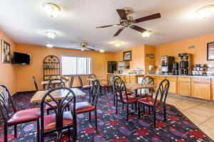 a dining room with tables and chairs and a kitchen at Econo Lodge & Suites in Pekin