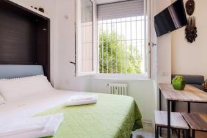 Habitación pequeña con cama y ventana en ℒovely & ℰlegant Studio next to Duomo/Missori, en Milán