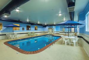 a large swimming pool with tables and umbrellas at Sleep Inn & Suites in Danville