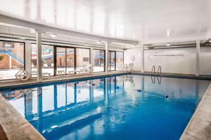 a large indoor swimming pool with blue water at Rodeway Inn Lyons - La Grange in Lyons