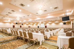 a banquet hall with tables and chairs and a screen at Clarion Inn Elmhurst - Oak Brook near I-88 I-290 I-294 in Elmhurst